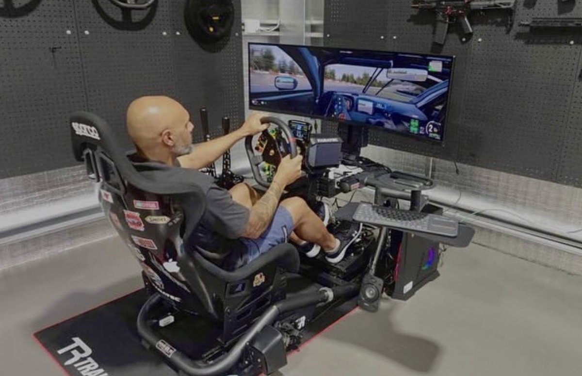 Driver racing on Trak Racer setup with triple monitors